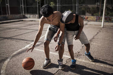 Young afro boy with his brother plays basketball on the court of his neighborhood - ADSF05371