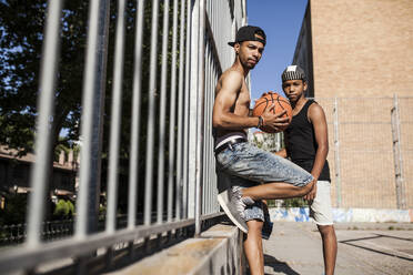 Junge Afro-Brüder spielen Basketball auf dem Platz in ihrer Nachbarschaft - ADSF05377