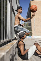 Junge Afro-Brüder spielen Basketball auf dem Platz in ihrer Nachbarschaft - ADSF05378