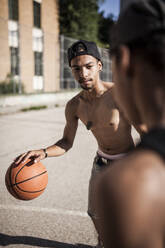 Junge Afro-Brüder spielen Basketball auf dem Platz in ihrer Nachbarschaft - ADSF05381