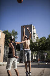 Junge Afro-Brüder spielen Basketball auf dem Platz in ihrer Nachbarschaft - ADSF05382