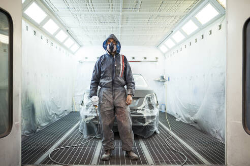 Painter posing in front of the booth before painting a car - ADSF05406