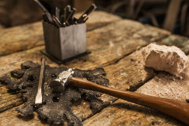 Schnittansicht von Hammer und Instrumenten auf einem hölzernen metallurgischen Tisch - ADSF05457