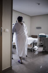 Unerkennbare reife Frau, die wegen einer Knieoperation im Krankenhaus liegt, geht durch das Zimmer - ADSF05461