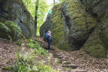 Senior man with backpack standing on steps in Thuringia forest, Germany - GWF06650