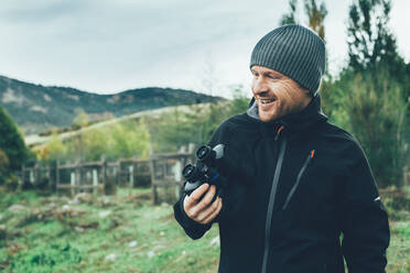 A young caucasian man with binoculars in te mountain in autumn colors - ADSF05625