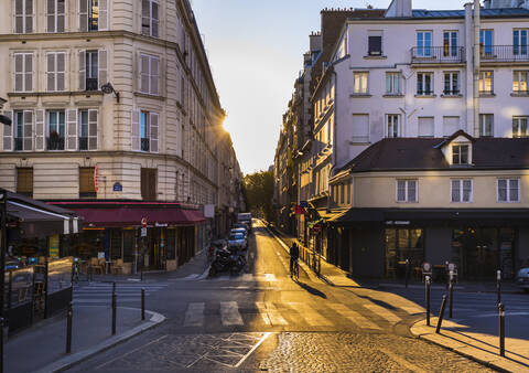 Road by buildings against clear sky during sunset, Paris, France stock photo