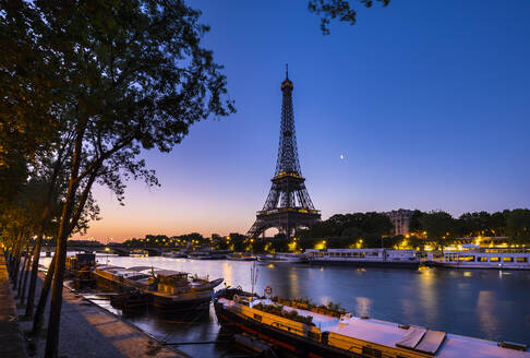 Eiffel Tower by Seine river against clear blue sky at sunset, Paris, France - HSIF00790