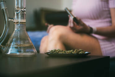 Woman preparing marijuana in a glass blunt - ADSF05673