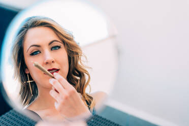 Junge Frau raucht einen Cannabis-Joint vor dem Spiegel - ADSF05702