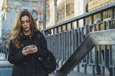 Frau benutzt Smartphone in der Nähe der U-Bahn - ADSF05778