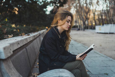 Frau liest Buch im Park - ADSF05779