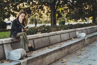 Frau liest Buch im Park - ADSF05783