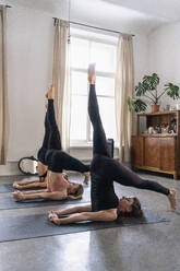 Junge Frauen üben Yoga im Yogastudio - FSIF05073