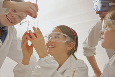 Happy junior high students in goggles conducting scientific experiment - FSIF05102
