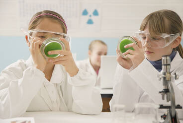 Junior high school girl students with petri dishes in science laboratory - FSIF05105