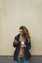 Frau mit Smartphone und Kaffee zum Mitnehmen - ADSF06006