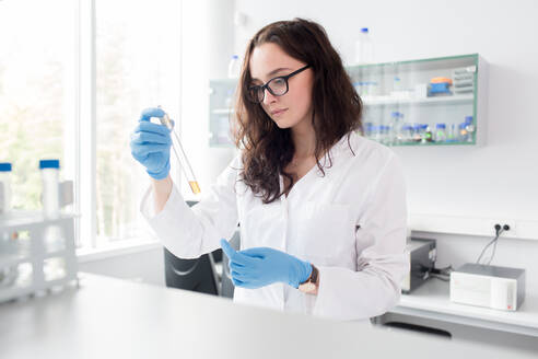 Woman looking at test tube - ADSF06036