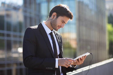 Eleganter junger Geschäftsmann auf der Straße mit einem digitalen Tablet - ADSF06038