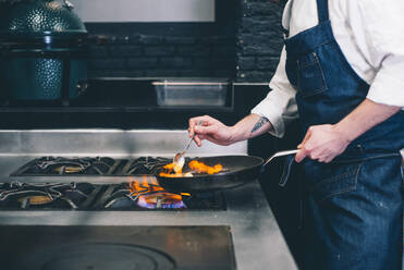 Cook making flambe in restaurant - ADSF06093