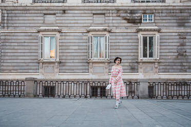 Young woman with theatrical costume and white mask while acting on street of city - ADSF06131