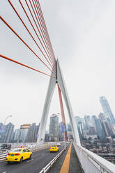 Perspektivische Ansicht einer modernen Hängebrückenkonstruktion mit Karte vor dem Hintergrund der Metropole Chongqing - ADSF06147