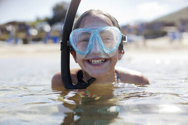 Glückliches Mädchen mit Schnorchel und Schwimmbrille im Meer - CAIF28387
