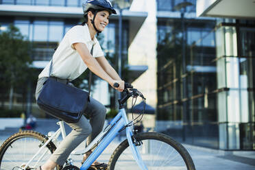 Geschäftsfrau Fahrradfahren außerhalb städtischen Gebäude - CAIF28460