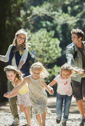 Family running in woods - CAIF28543