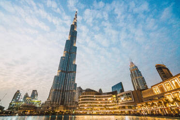 Von unten blauer Himmel mit weißen Wolken über beleuchteten modernen Wolkenkratzern auf der Straße von Dubai - ADSF06184