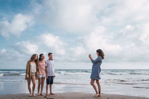 Rückansicht einer Frau, die im Freien Kinder mit ihrem Smartphone fotografiert - ADSF06268