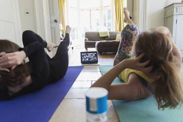 Mutter und Tochter nehmen an einem Online-Yogakurs zu Hause teil - CAIF28621