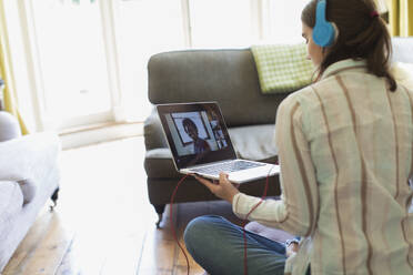 Teenager-Mädchen mit Kopfhörern und Laptop im Videochat mit Freunden - CAIF28662