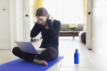 Teenager-Mädchen übt Yoga online mit Laptop - CAIF28674