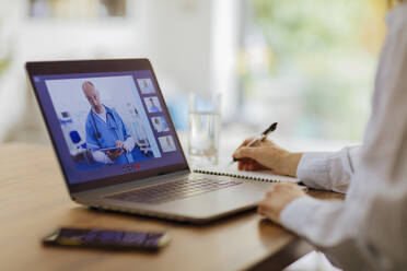 Frau bei Videokonferenz mit Arzt am Laptop - CAIF28736