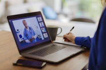 Frau bei Videokonferenz mit Arzt auf Laptop-Bildschirm - CAIF28762