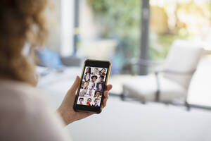 Frau im Videochat mit Freunden auf dem Bildschirm eines Smartphones - CAIF28763