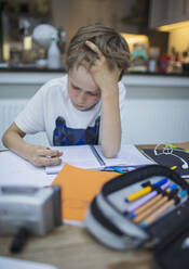 Konzentrierter Junge beim Hausunterricht am Tisch - CAIF28779