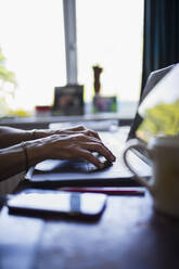 Hands of woman typing on laptop working from home - CAIF28781
