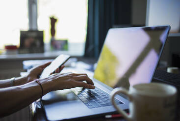 Close up woman working from home at laptop in home office - CAIF28788