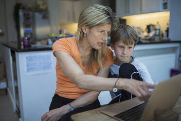 Mother helping son with homework at laptop - CAIF28790