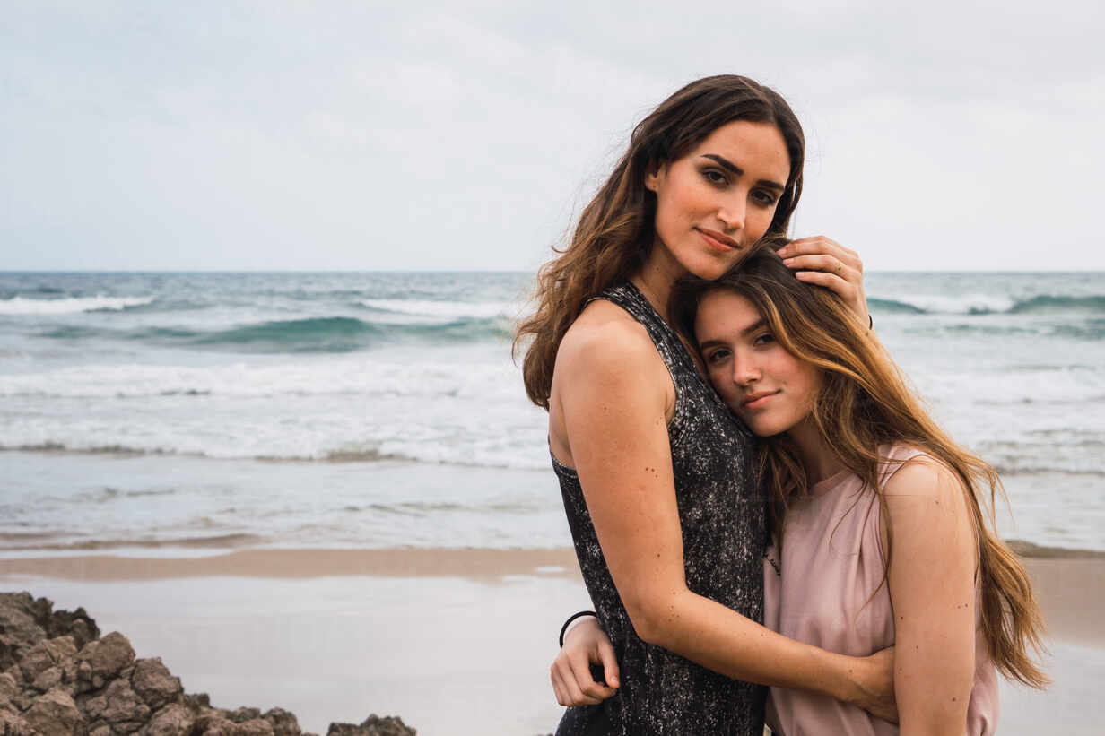 Zwei Mädchen Stehen In Umarmung Und Lächelnd Neben Dem Meer Lizenzfreies Stockfoto 
