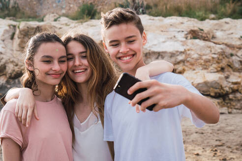 Gruppe lächelnde Kinder nehmen Selfie am Meer - ADSF06277