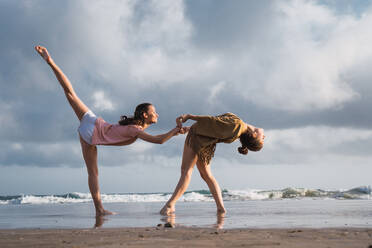 Freunde machen Übungen am Strand - ADSF06283