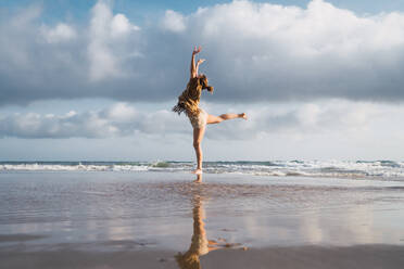 Frau macht Übungen am Strand - ADSF06286