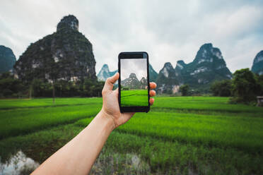 Crop hand taking photo in rice fields of Chinese Guangxi - ADSF06327