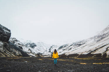 Woman standing near snowy mountains - ADSF06355