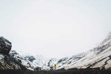 Woman standing near snowy mountains - ADSF06356