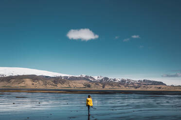 Back view of female standing near beautiful mountains with clear sky - ADSF06358