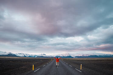 Man standing on road near mountains - ADSF06361